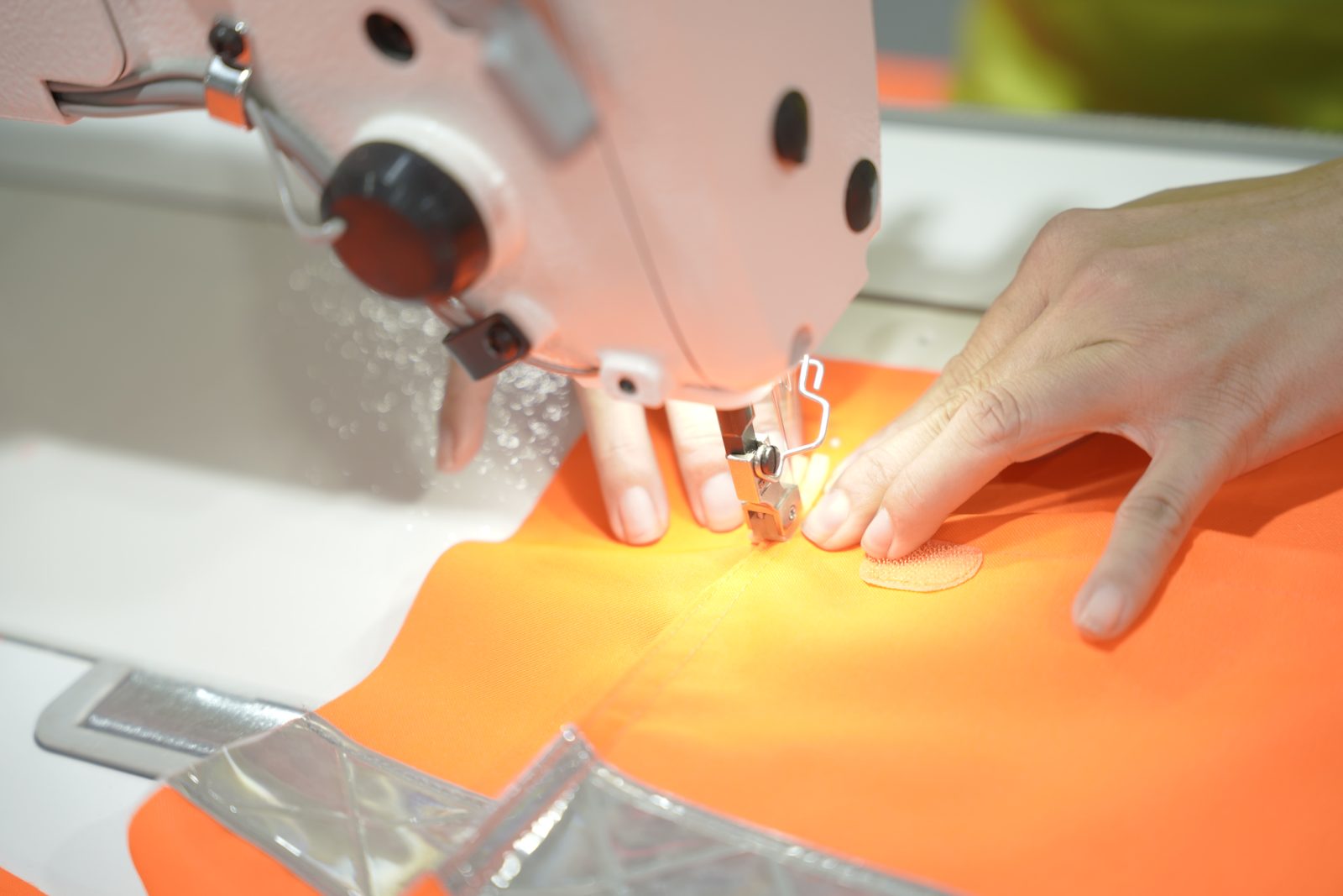 A Viking Vietnam operator sewing reflective detail onto waterproof fabric on the sewing line
