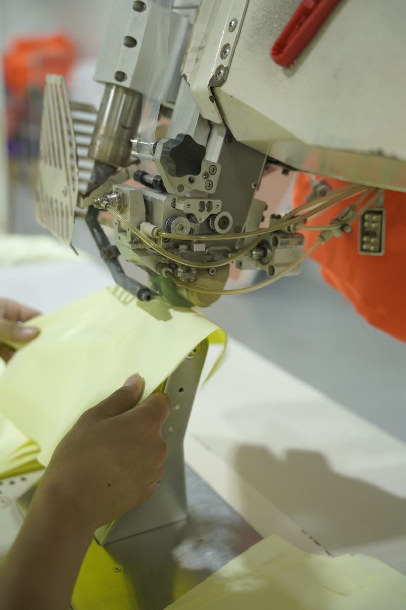 Seam tape being fed into equipment at the Viking Vietnam factory, a functional trim that needs checking before the style reaches the line