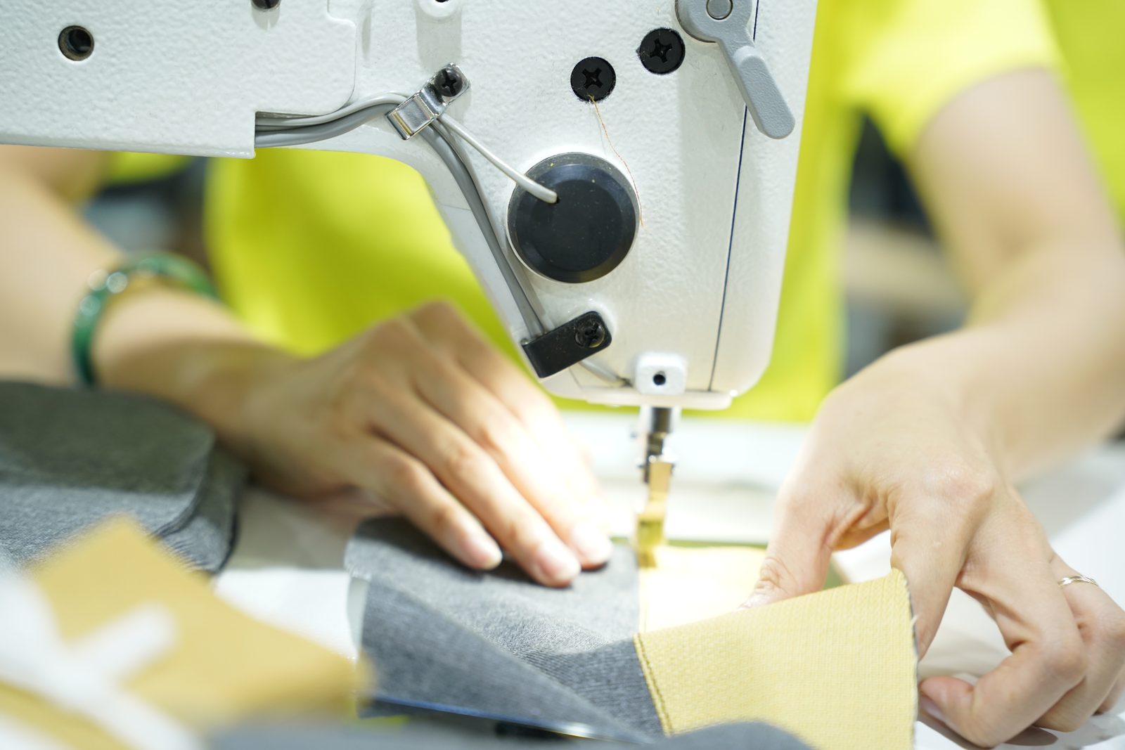 A Viking Vietnam operator positioning a detail with both hands before sewing, a control step during the pilot piece stage