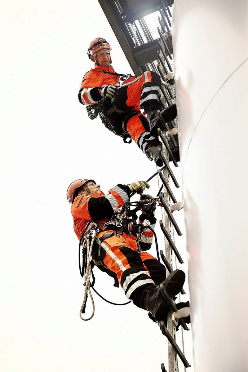 Technician climbing a ladder in thermal protective workwear